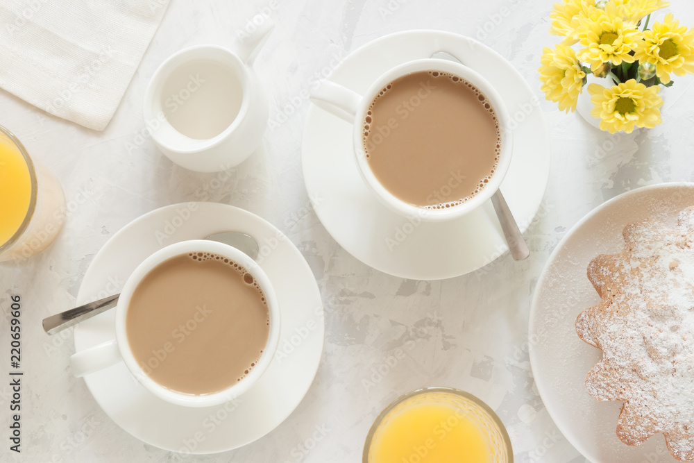 两人一杯的早晨咖啡，配奶油、蛋糕、橙汁和一小束黄色的花