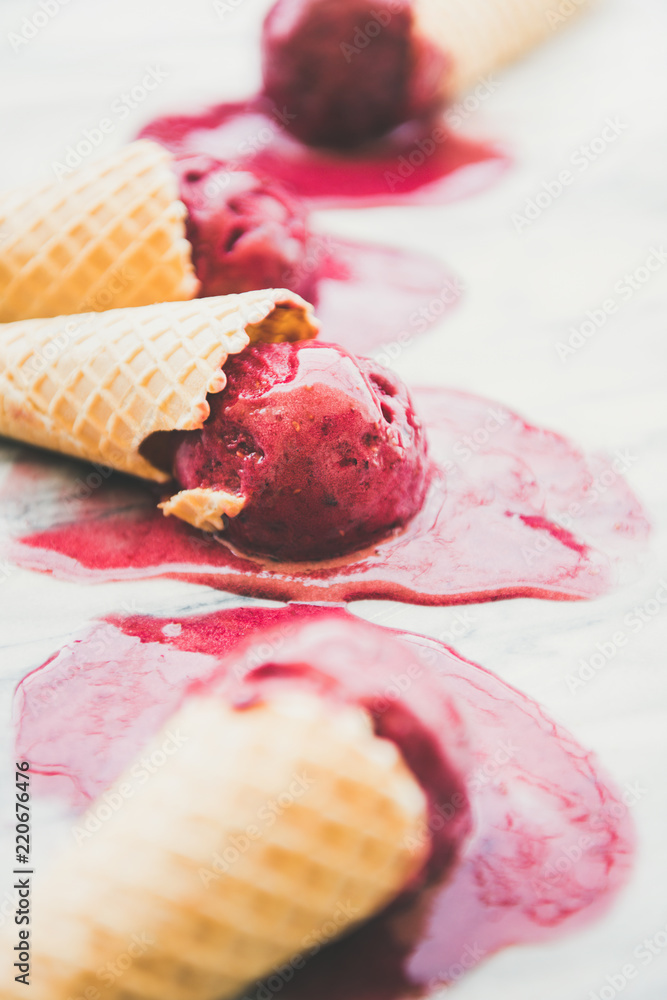 新鲜的夏季甜点。融化的天然树莓冰糕冰淇淋舀在甜华夫饼蛋卷中，超过m