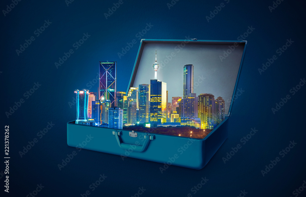 蓝色背景下，一个开放的复古行李箱中的夜景现代城市摩天大楼。