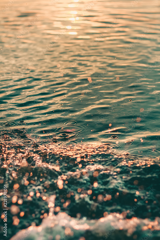 日落时有水滴和飞溅物的水面和绿松石色的水面
