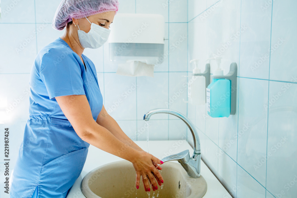女医生妇科医生在轻型手术室手术前或手术后洗手。