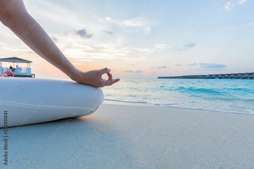 日落时分，马尔代夫海滩上练习瑜伽莲花式冥想的女人的特写手，F