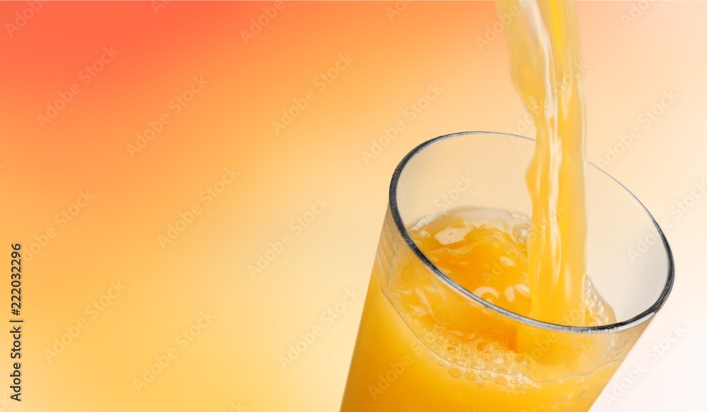 橙汁倒在背景玻璃中