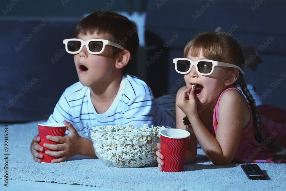 戴着3d眼镜的可爱孩子晚上在地毯上看电影