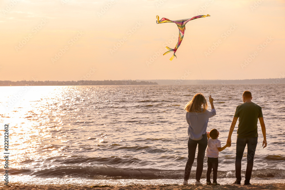 日落时分，幸福的一家人在河边放风筝