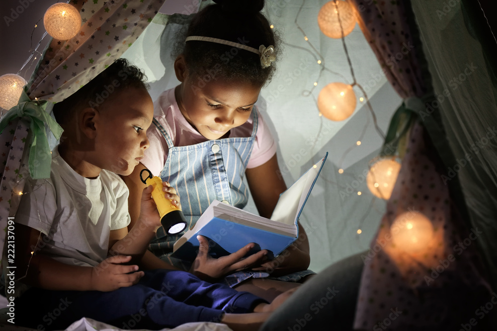 小非洲裔美国儿童在小屋里读睡前故事