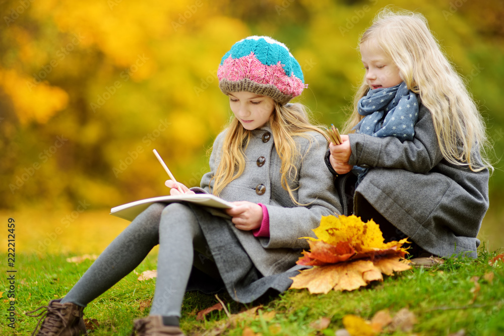 美丽的秋日，可爱的小女孩在外面写生。快乐的孩子们在秋天的公园里玩耍。