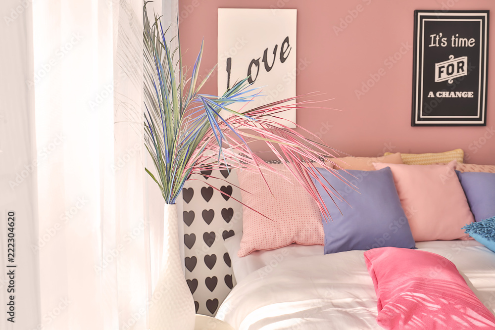 现代舒适卧室内部桌子上的彩色热带树叶花瓶