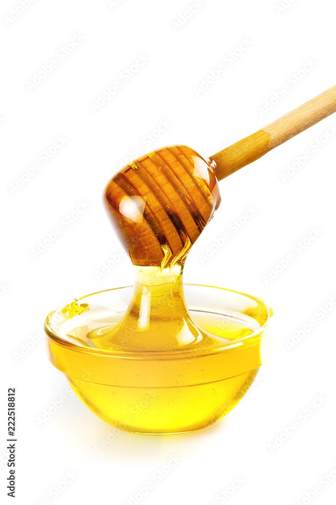 蜂蜜用勺子放在光滑的玻璃碗里