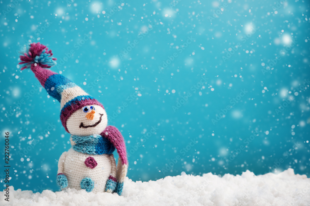 蓝色背景下松软雪地上的小雪人