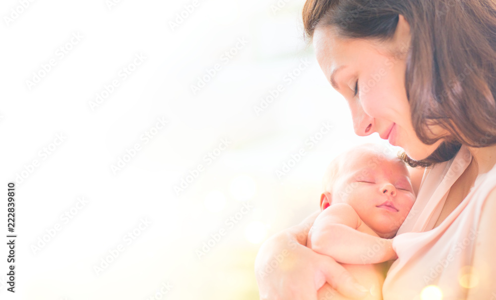 母亲和她的新生儿在一起。快乐的母亲和婴儿亲吻和拥抱。母性概念。