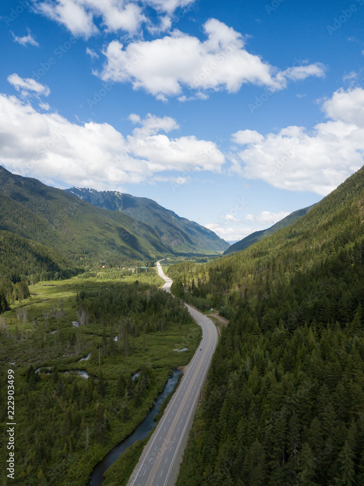穿越美丽的加拿大山脉环绕的山谷的风景公路鸟瞰图