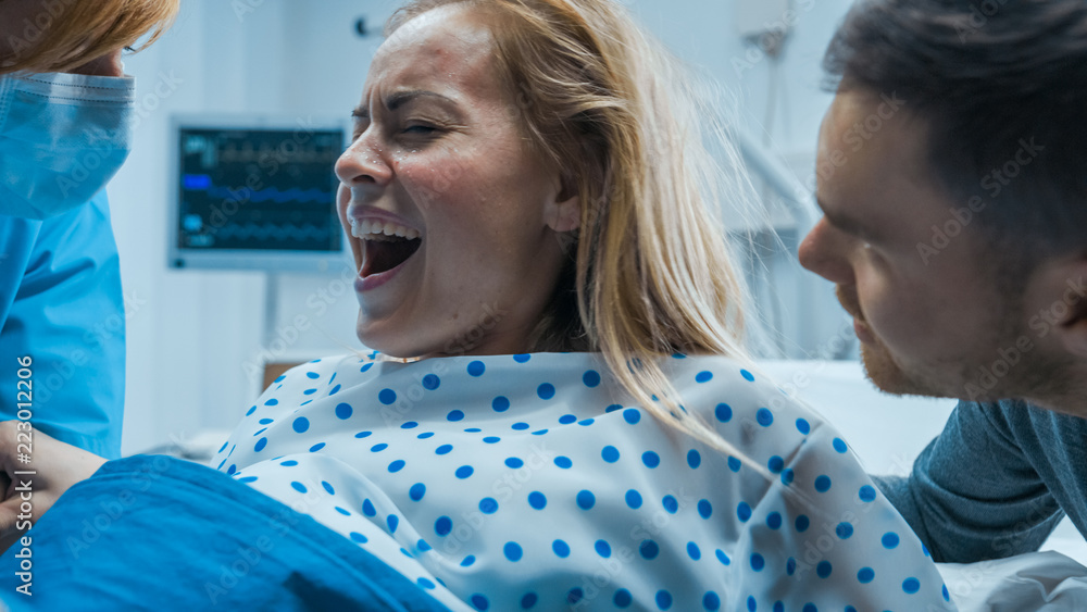 在医院里，一名分娩中大喊大叫的妇女奋力分娩的特写镜头。现代产妇