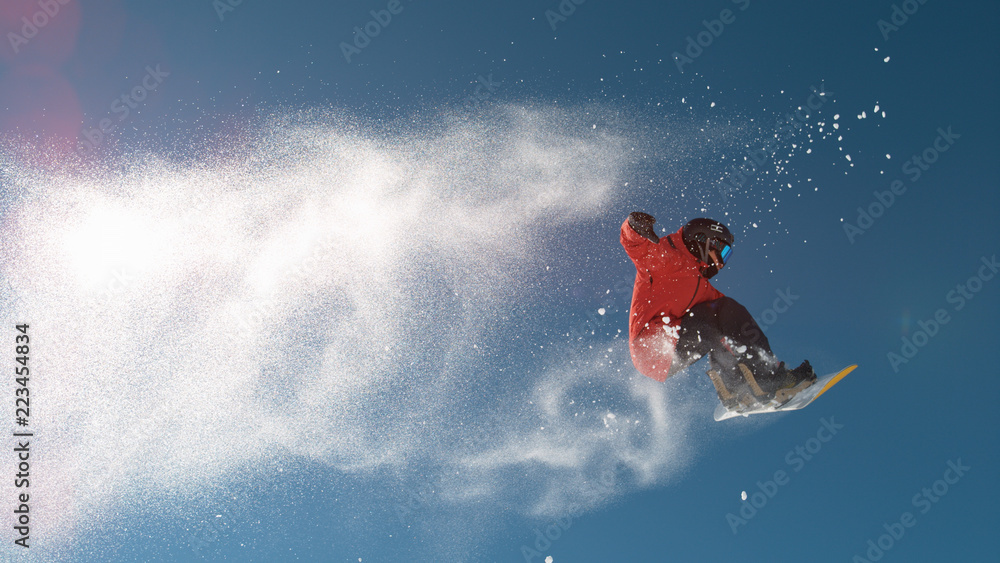 慢动作：冬天，滑雪运动员在高空跳跃，身后雪花飞舞