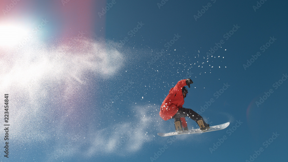 慢动作：冬天，滑雪运动员在高空跳跃，身后雪花飞舞