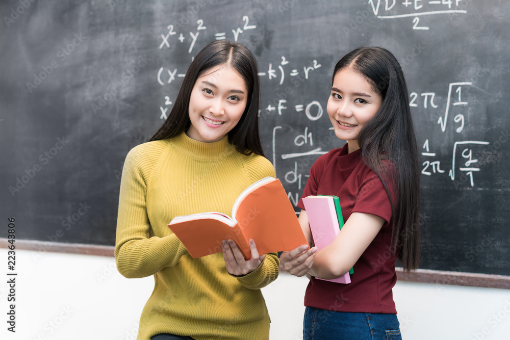 亚洲女学生在大学的教室里一起拿着黑板看书。Ed