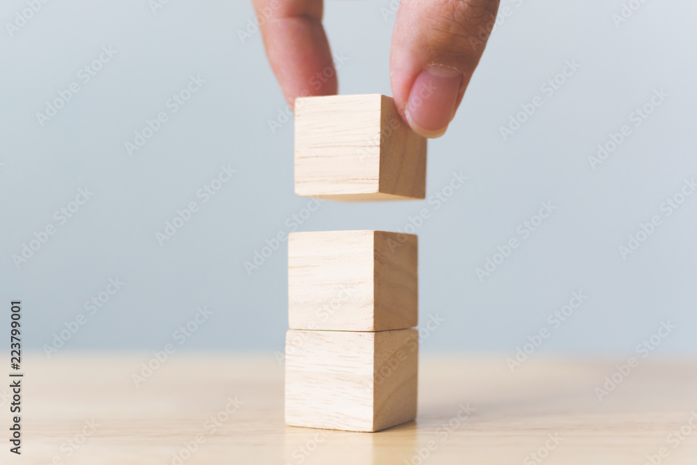 用木桌在顶部手工安排木块堆叠。增长成功的商业理念