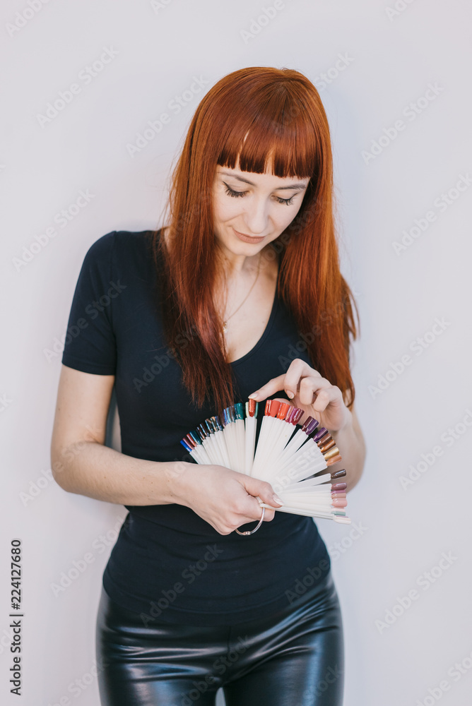 漂亮的美甲师讲述她手中五颜六色的漆凝胶样本。特写