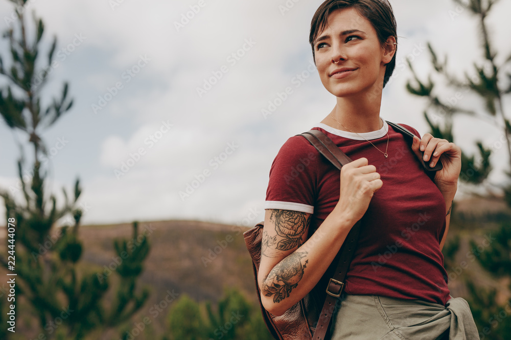 Woman hiker carrying a backpack looking away