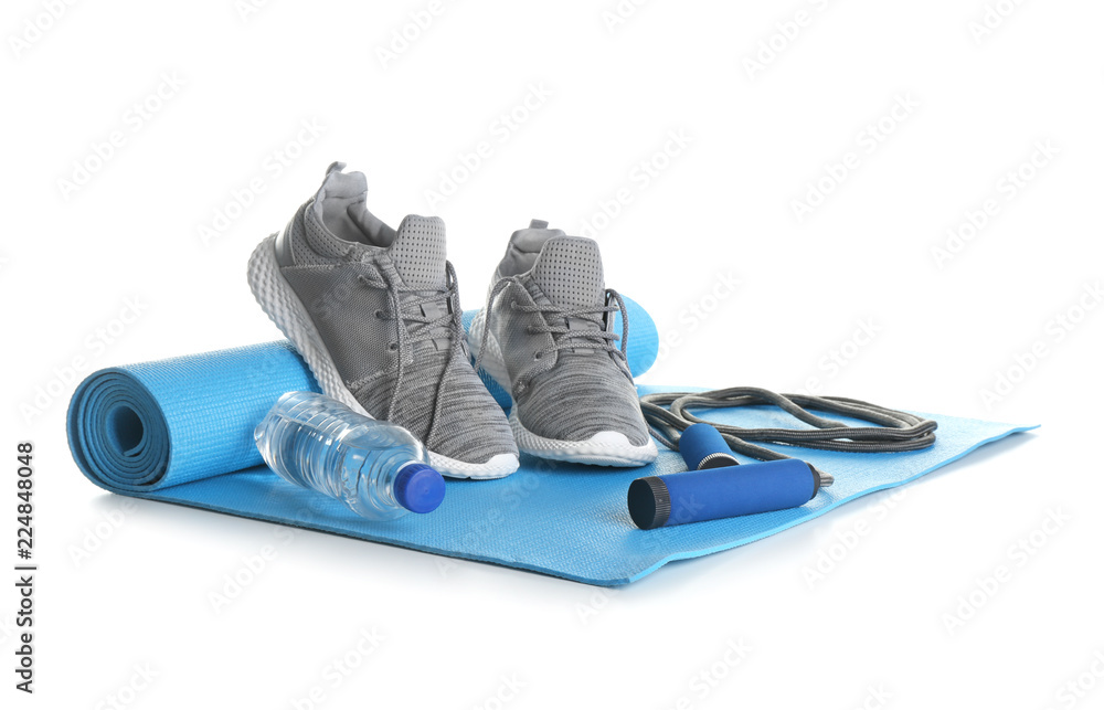 瑜伽垫配运动鞋、跳绳和白底水瓶