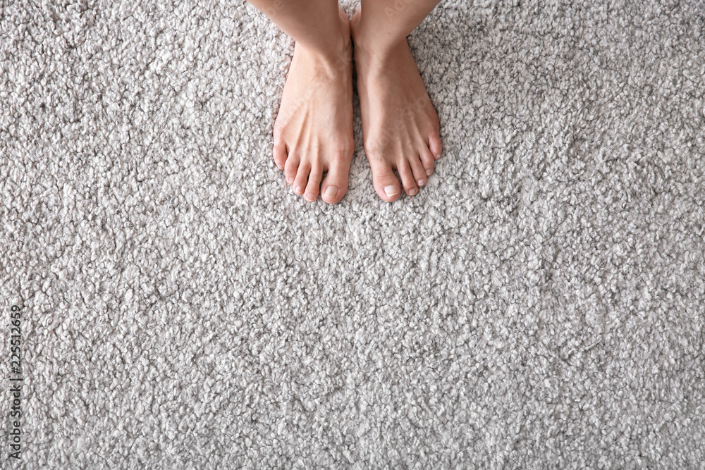 Barefoot woman standing on carpet
