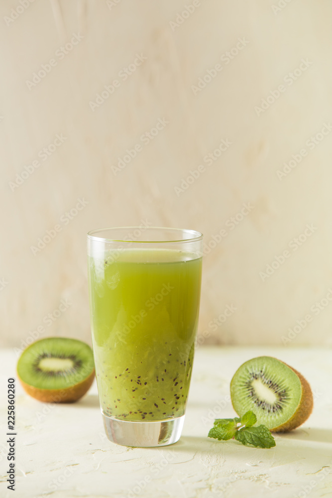Cocktail with kiwi and mint in a glass on a light green background. Selective focus.