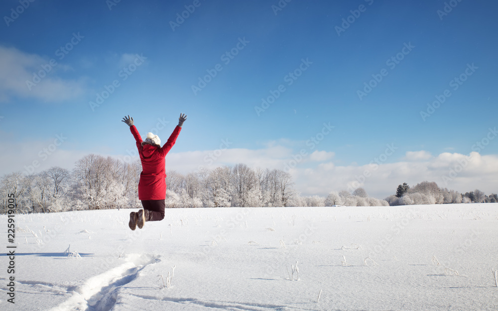 雪景上的冬日风景里的快乐女人。晴天户外的人