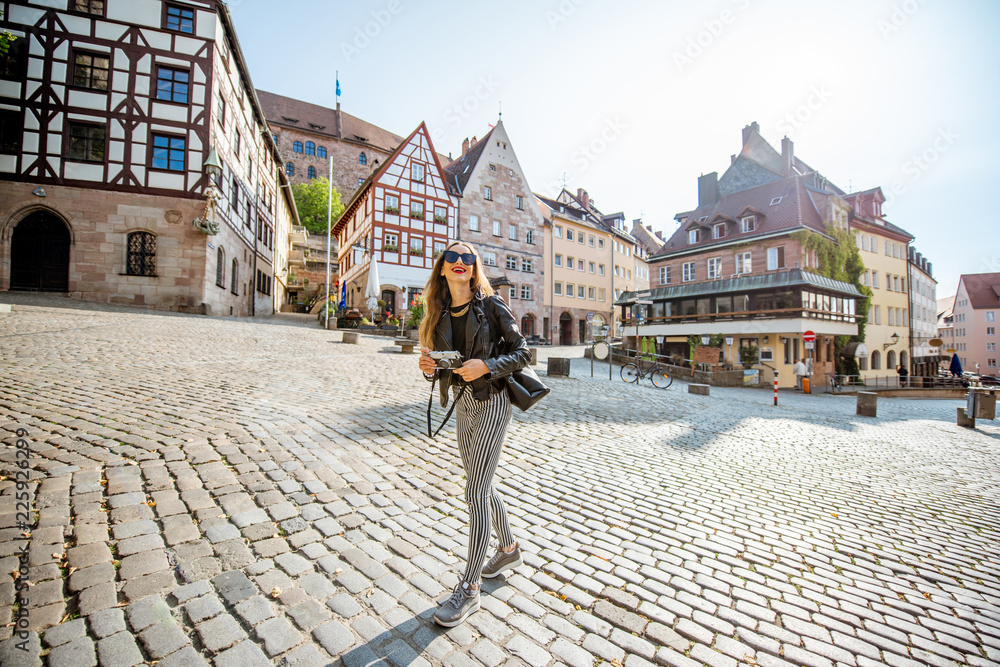年轻的女游客走在德国纽伦堡老城美丽的城市广场上