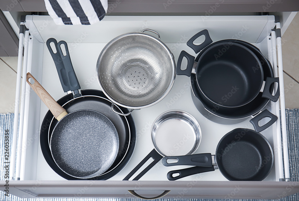 Set of clean kitchenware in drawer
