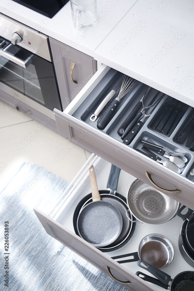 打开抽屉的一套清洁厨具和用具