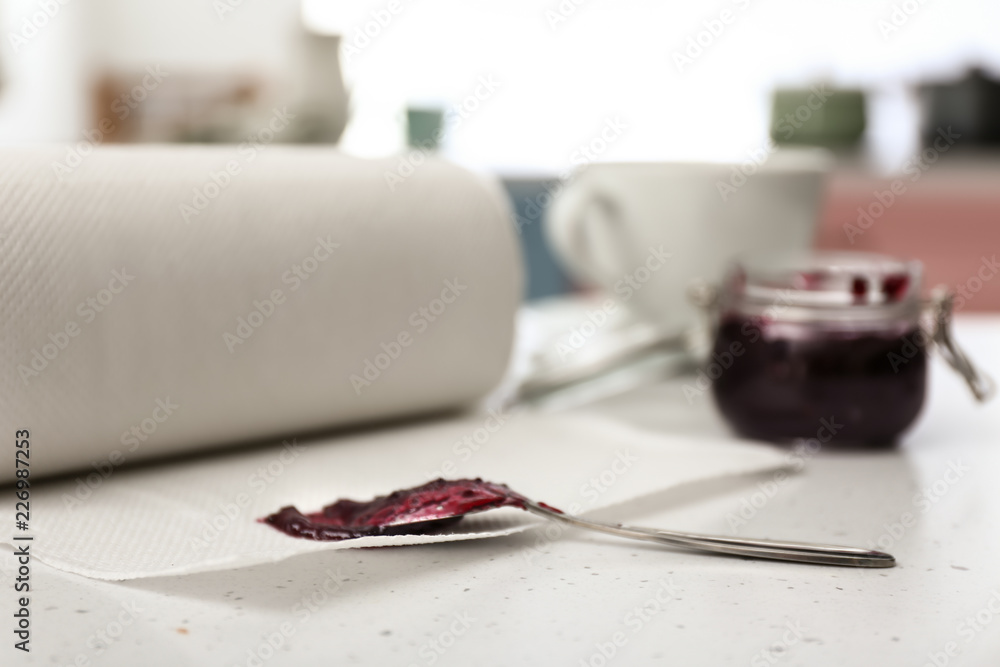 白色桌子上有果酱的纸巾和勺子卷