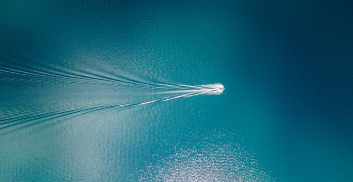 在加利福尼亚州塔霍湖蓝色清澈水域航行的船只的无人机视图