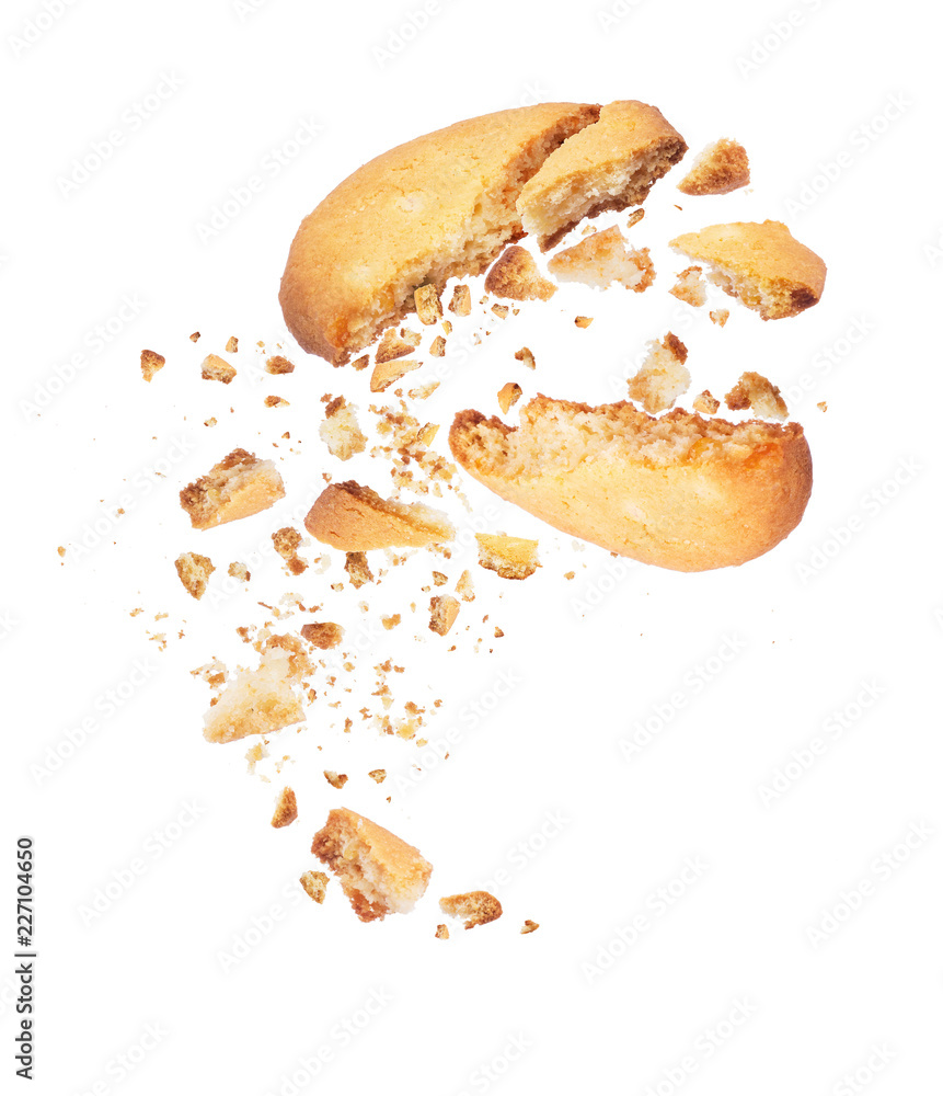 Biscuit broken into two halves with falling crumbs down, isolated on white background