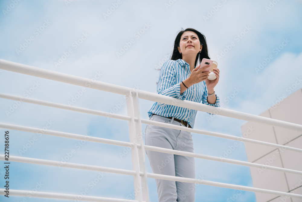 一个优雅的女人站在户外，天空湛蓝