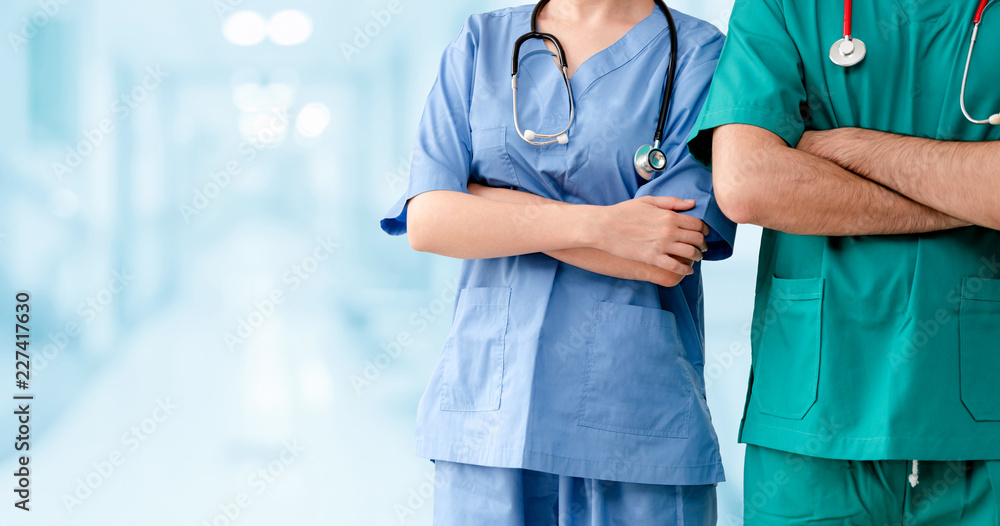 两名医院工作人员——外科医生、医生或护士交叉双臂站在医院里。医务人员h