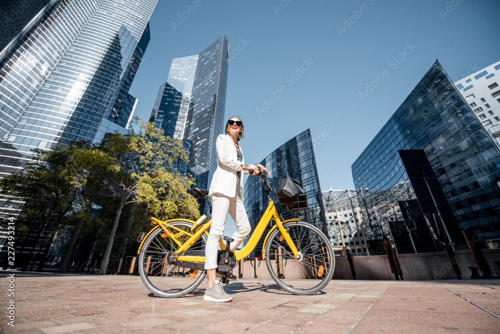 一位身穿白色西装、骑着自行车站在金融区w的时尚商务女性的肖像