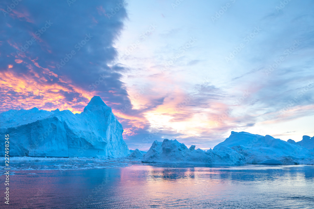 日落时，有趣多彩的天空下有一座上镜的复杂冰山。格雷的迪斯科湾