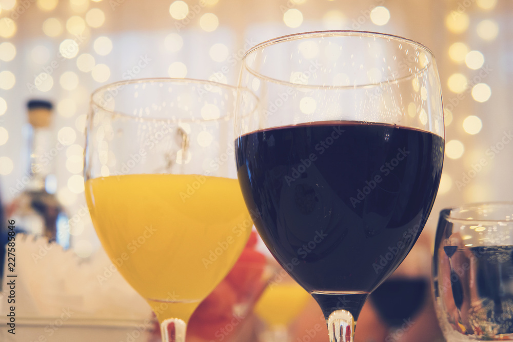 garlands cur餐厅桌子上放着红酒和橙汁的玻璃杯的特写