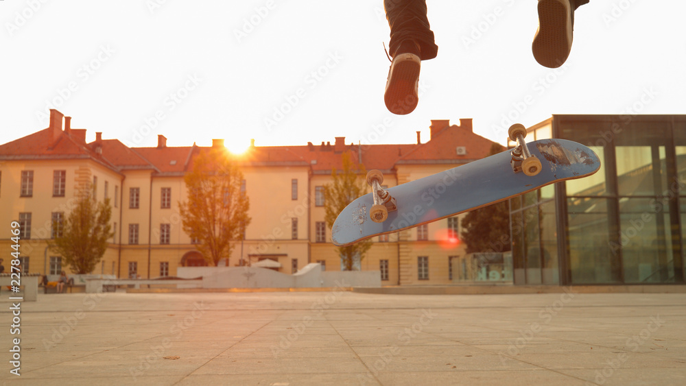 镜头闪光：无法辨认的运动型男子在滑板上玩翻转动作。