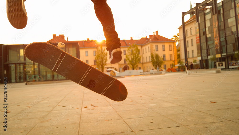 LENS FLARE：在一个阳光明媚的秋夜，一个不知名的滑板运动员做了一个翻转动作。