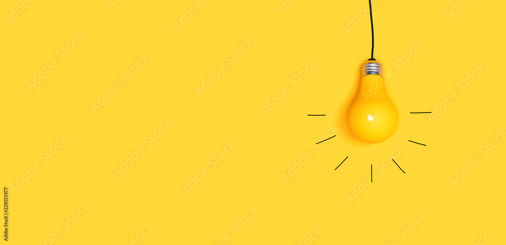 一个挂在黄色背景上的灯泡