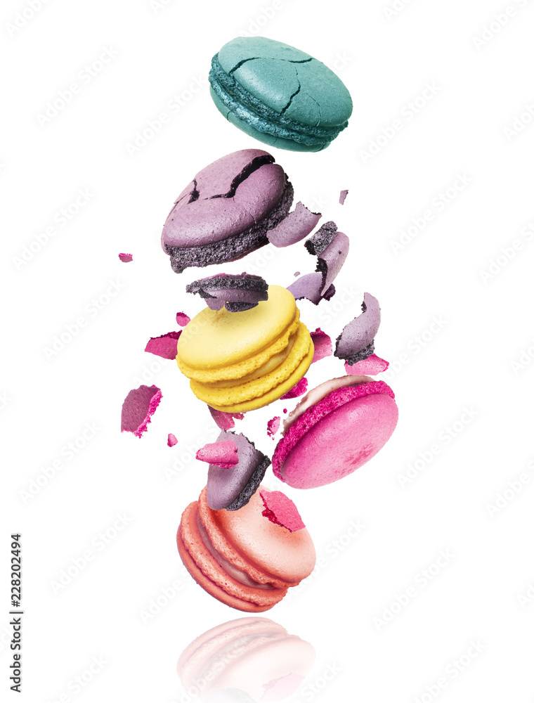 Сolored macaroons crushed into pieces in the air, isolated on a white background