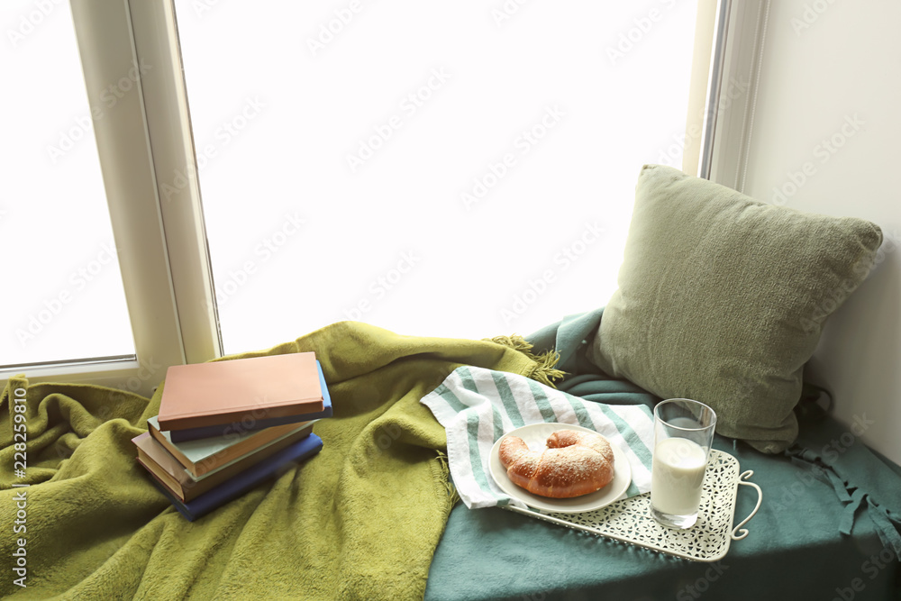 舒适的休息场所，窗台上有书和美味的早餐