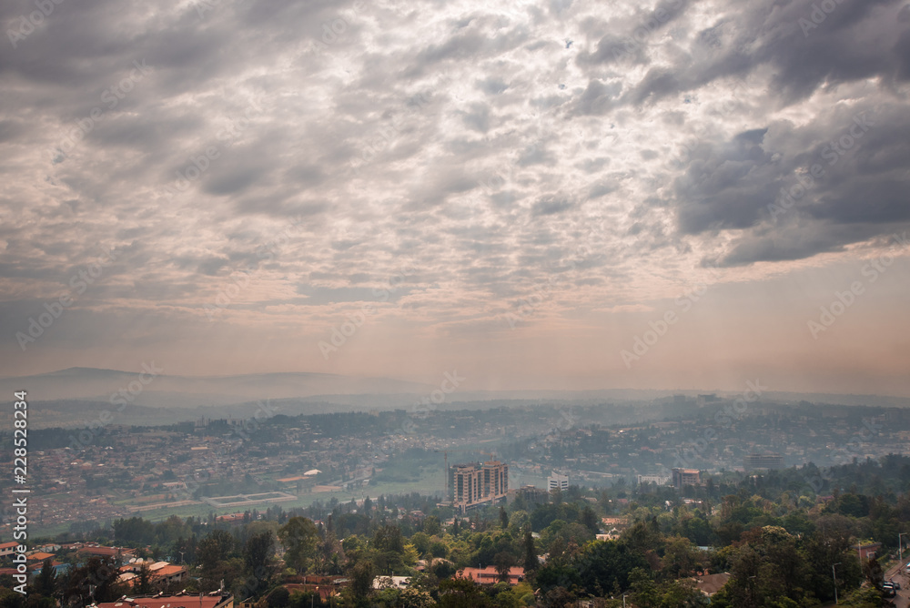 阳光穿透卢旺达群山上空的云层，一直延伸到远处