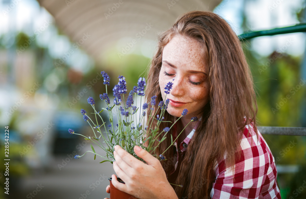 花园中心的年轻女子闻到盆栽薰衣草的花香