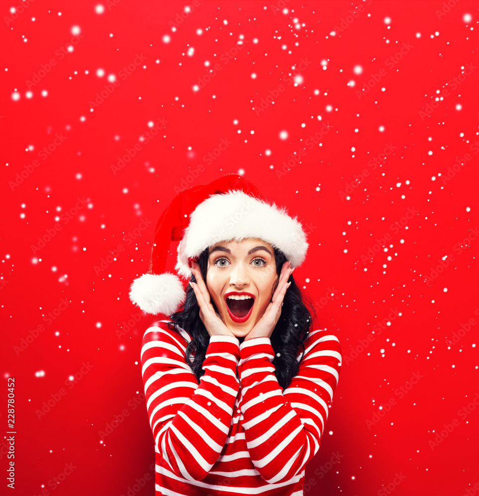 红底戴圣诞老人帽的快乐年轻女人