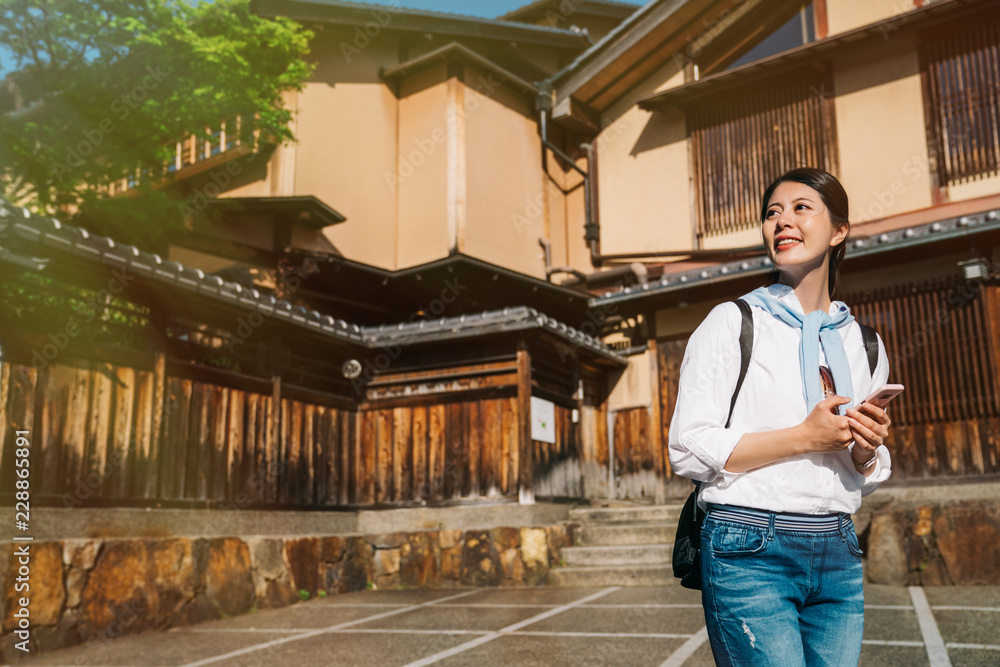 tourist standing next to wooden Japanese building
