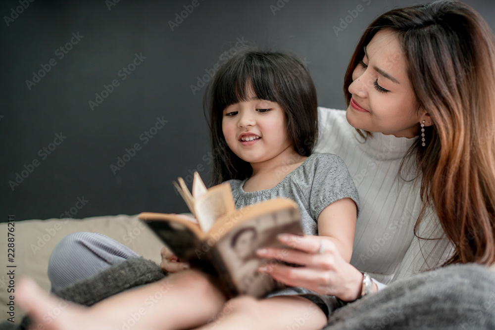 美丽的亚洲单身妈妈和可爱的女儿幸福时刻教家庭作业在家上学的想法