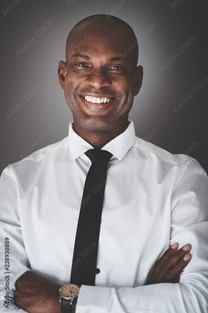 微笑的年轻非洲商人站在灰色的背上