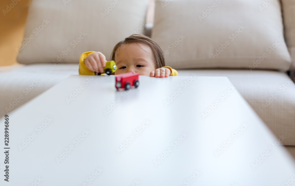 Toddler boy playing with toys in his house